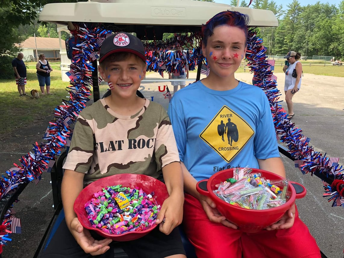 Two boys on golf cart with Fourth of July decorations