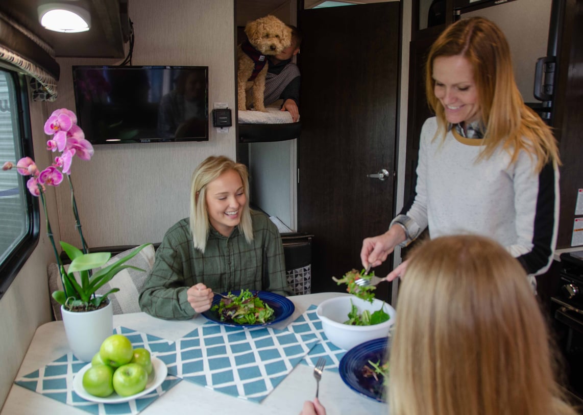 Mother serving daughters salad in RV